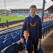 The Rangers fan with his son inside Dens Park on Sunday