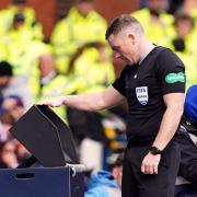 John Beaton views the incident at the pitchside monitor